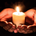 Bøn for klimaet Bedende hænder med lys